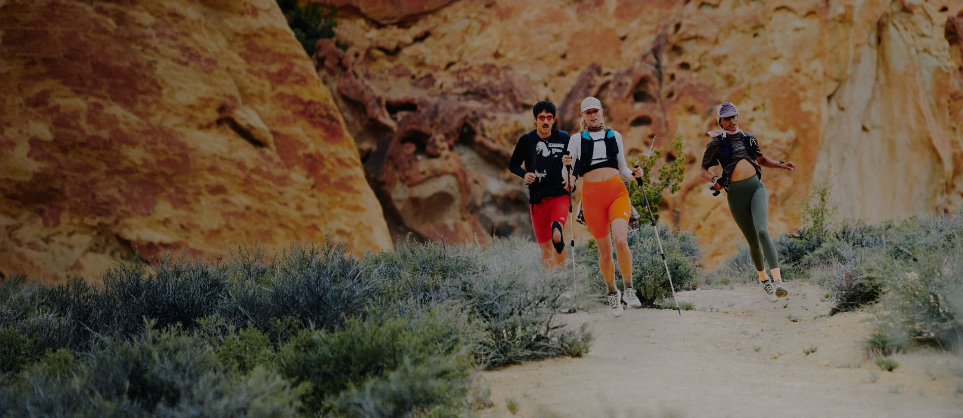 Runner uomo e donna con scarpe trail running KEEN su percorso outdoor tra rocce e sabbia