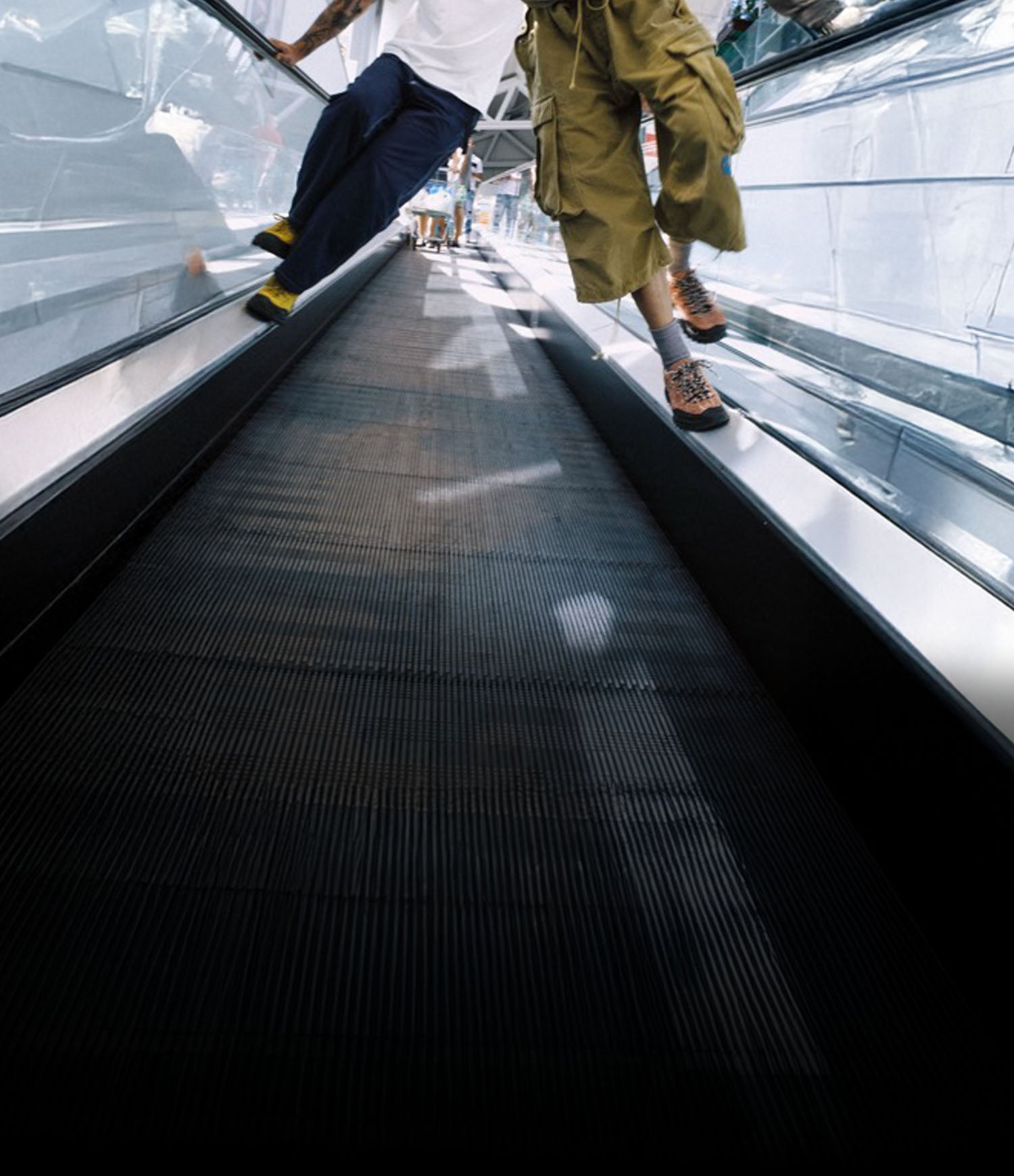 Donna con scarpe KEEN Jasper Zionic che cammina su passerella mobile in ambiente urbano