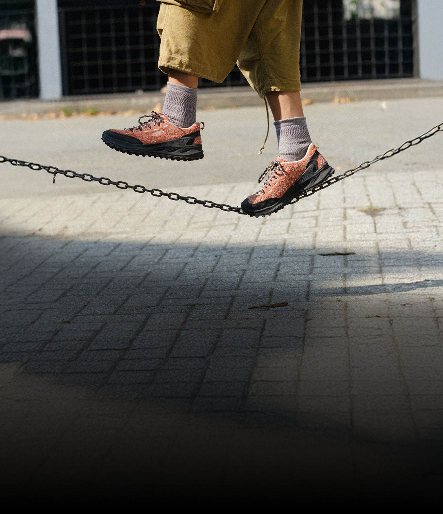 Donna con scarpe KEEN Jasper Zionic che cammina su passerella mobile in ambiente urbano