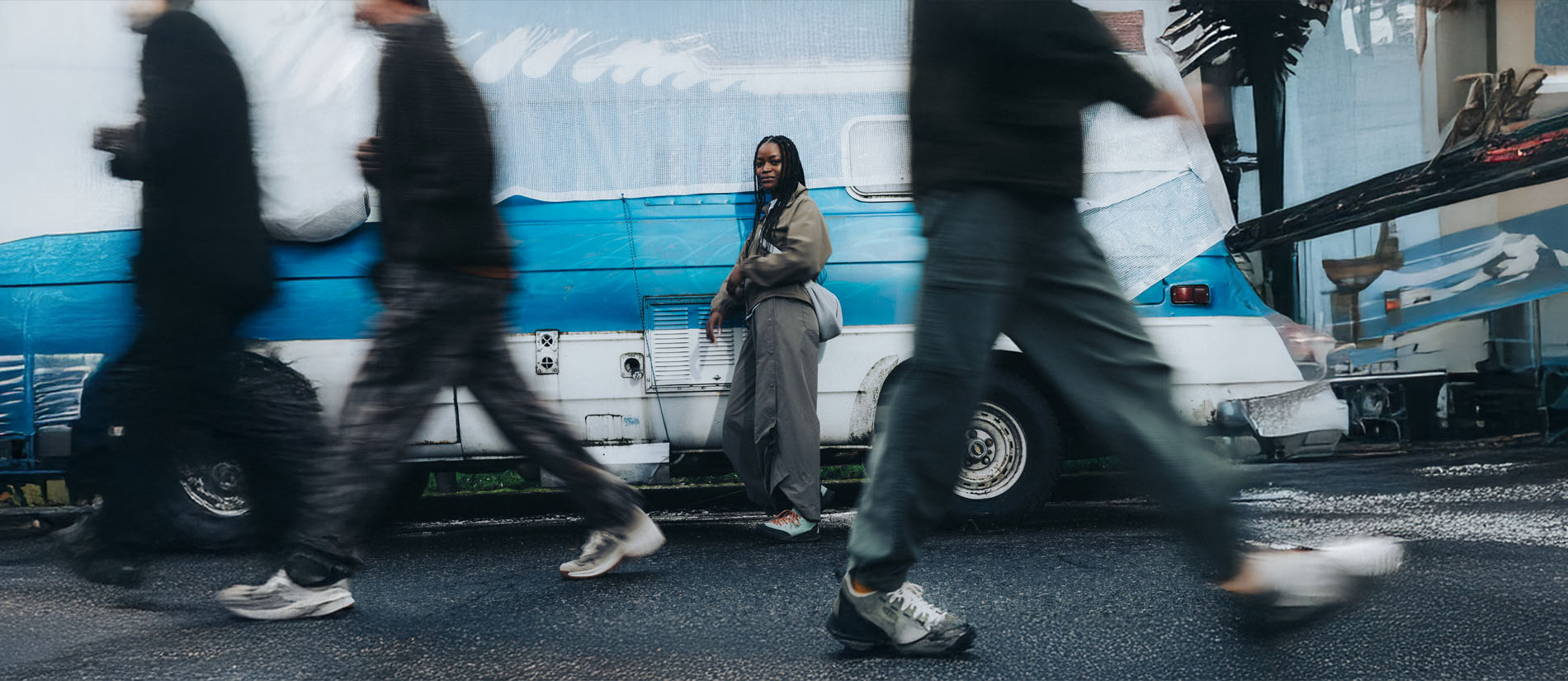 Donna con sneakers KEEN UNEEK da donna, stile lifestyle urbano e outdoor, fotografata in città davanti a un furgone vintage, scarpe comode e versatili ideali per il tempo libero e le avventure quotidiane.