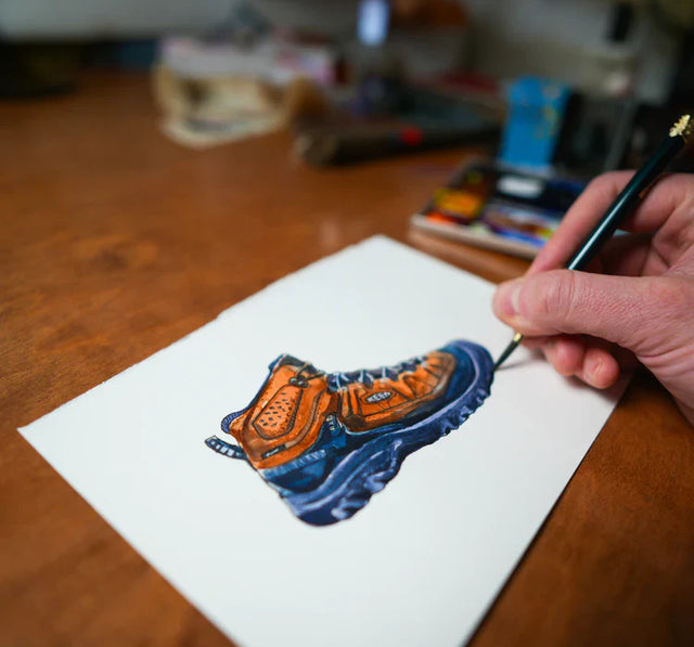 Illustrazione ad acquerello dettagliata di uno stivaletto KEEN da trekking arancione e blu.