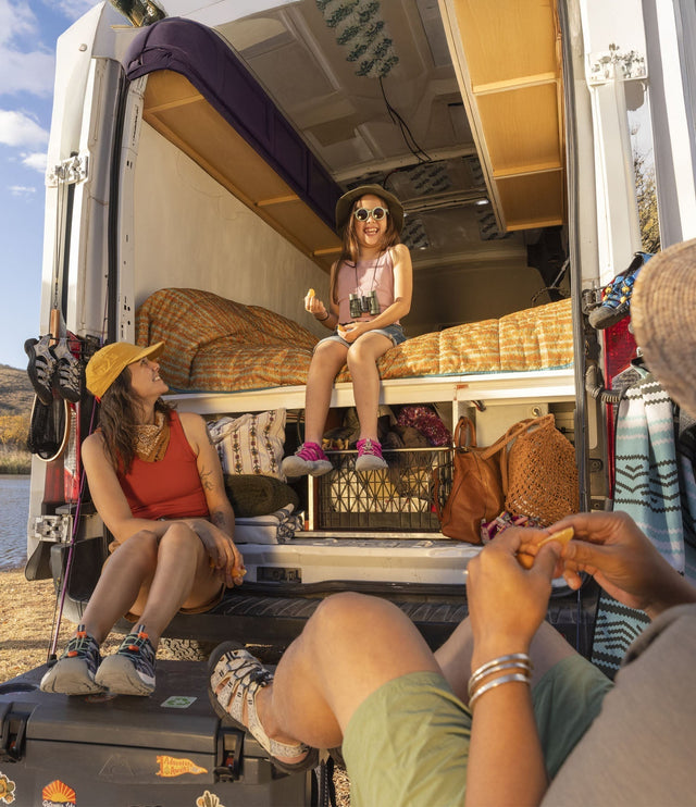Momento di relax durante una vacanza outdoor in camper, con tutta la famiglia che indossa sandali KEEN.