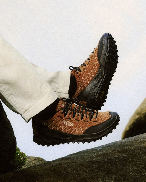 Dettaglio uomo con gambe sollevate che indossa sneakers keen jasper zionic collab gramicci