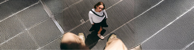 Scarpe KEEN Jasper indossate da una donna seduta su una scalinata, in un contesto cittadino tra lifestyle e quotidianità.