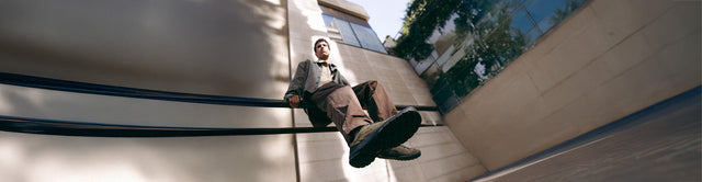 Scarpe KEEN Jasper Zionic indossate da un uomo seduto su una struttura in città, con suola in primo piano e focus sul design ibrido tra outdoor e quotidiano.