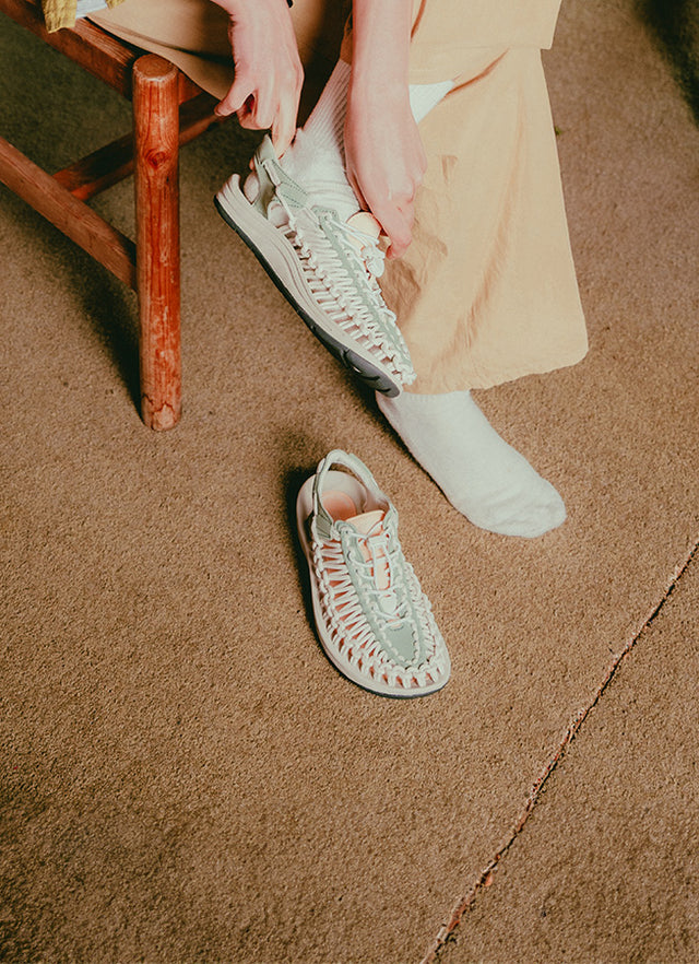 Sandali KEEN UNEEK con struttura intrecciata, indossati in contesto lifestyle tra città e tempo libero