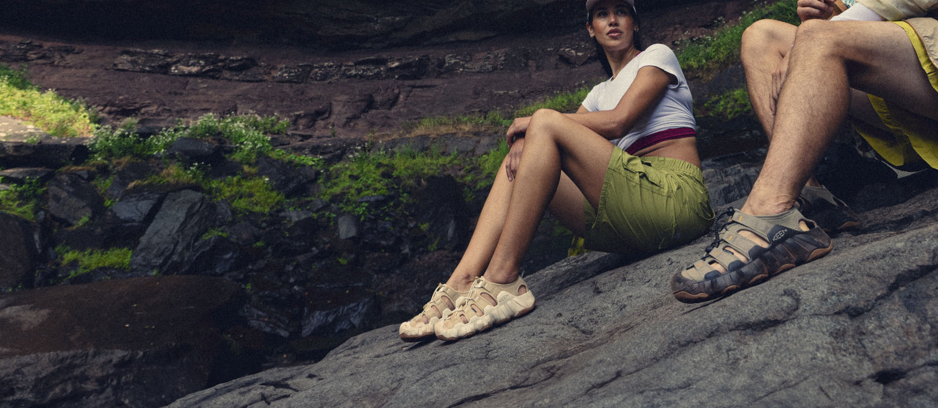 Sandali KEEN Newport e Hyperport indossati su rocce bagnate durante un percorso outdoor vicino all’acqua