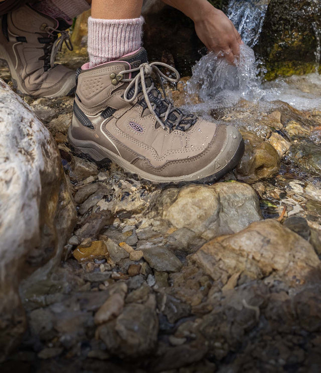 dettaglio donna su un fiume che indossa scarponcini resistenti all'acqua targhee iv marroni e rosa