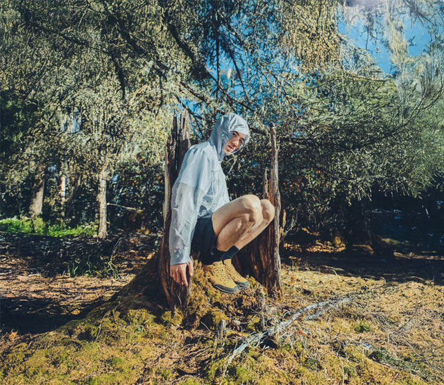 Uomo seduto su ceppo nel bosco con KEEN Jasper Zionic gialle ai piedi, look outdoor e utilizzo quotidiano