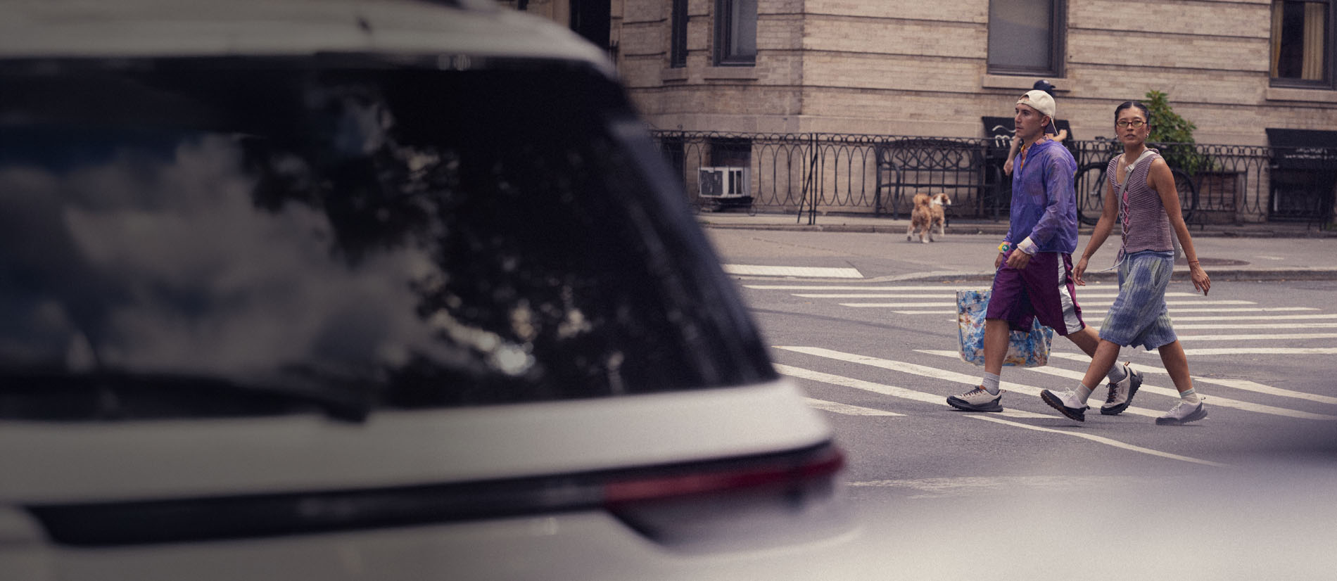 Persone attraversano la strada in città con scarpe KEEN urban outdoor, utilizzo quotidiano dinamico