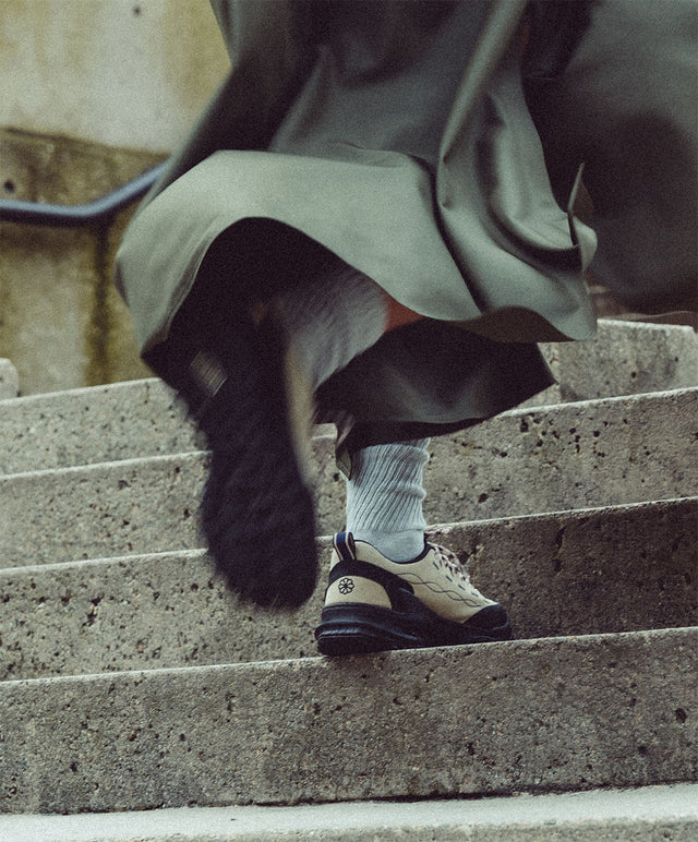 Scarpe KEEN Jasper Zionic beige indossate su una scalinata di cemento, stile urbano e dinamico.