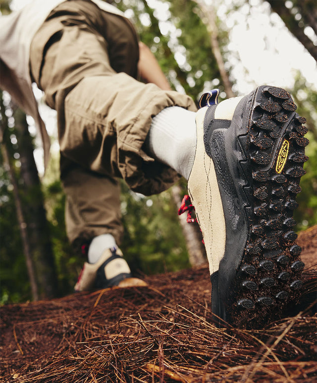 Dettaglio della suola con grip della scarpa KEEN Jasper Zionic durante un'escursione su terreno boschivo