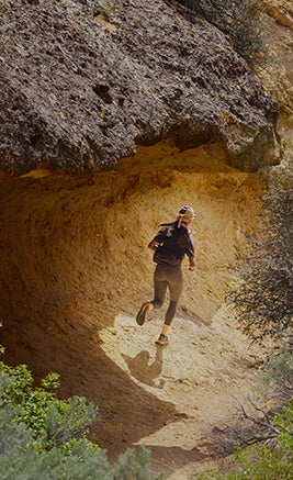 Scarpe da trail running KEEN appoggiate su terreno naturale, design tecnico con suola ad alta trazione per percorsi off-road.
