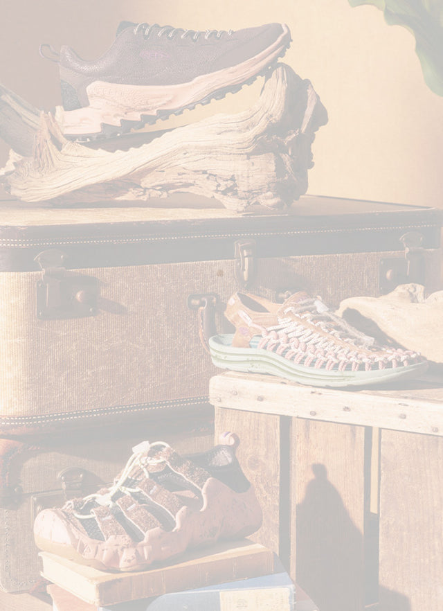 Runner con scarpe KEEN da trail running su un sentiero roccioso, con suola in primo piano.